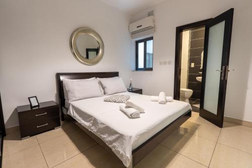 a bedroom with a large bed and a mirror at Spacious Ensuite Bedroom - Gzira in Il-Gżira