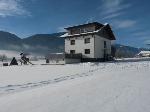 a house on top of a snow covered field at Nico's Place in Jenig