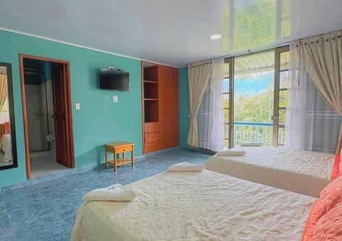a bedroom with two beds and a large window at VillaLoren in San Antonio del Tequendama
