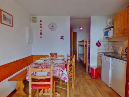 une cuisine avec une table et des chaises dans une pièce dans l'établissement Studio cabine avec alcôve pour 4 aux Saisies, balcon au sud - FR-1-594-162, à Hauteluce