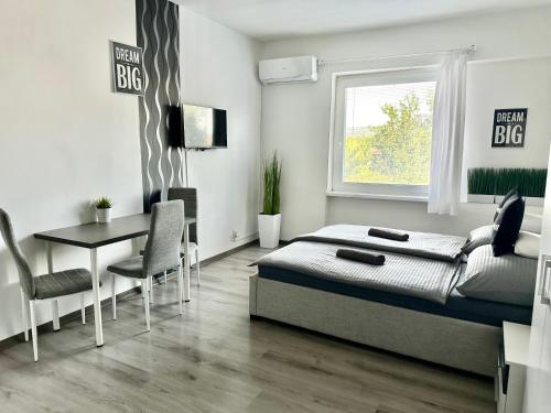 a bedroom with a bed and a table and a window at City Apartment in Štúrovo