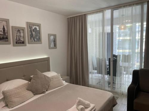Un dormitorio con una cama y una ventana grande. en On Beach-Mamaia Residence, en Mamaia Nord – Năvodari