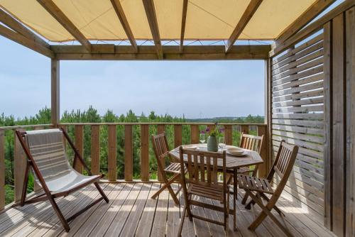 a patio with a table and chairs on a deck at Ohai Nazaré Outdoor Resort in Nazaré