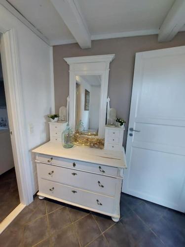 a white dresser with a mirror on top of it at FeWo Stjerneskud in Bindslev