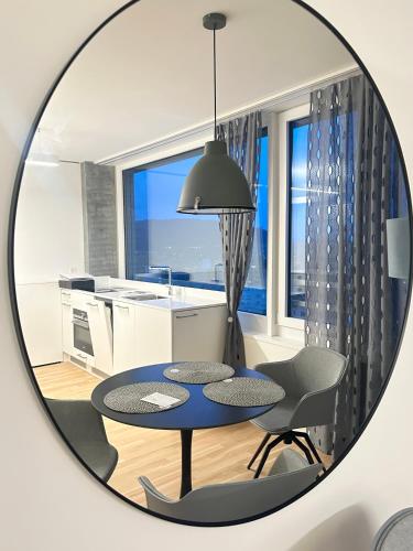 a mirror in a kitchen with a table and chairs at MydiHei @ Rhyfall Towers in Neuhausen am Rheinfall