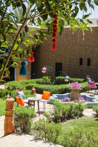 a garden with chairs and a table in a yard at Kasbah Agafay Hotel & Spa in El Karia