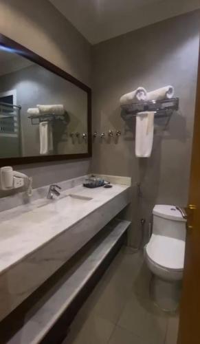 a bathroom with a sink and a toilet and a mirror at Reef Home Hotel in Riyadh