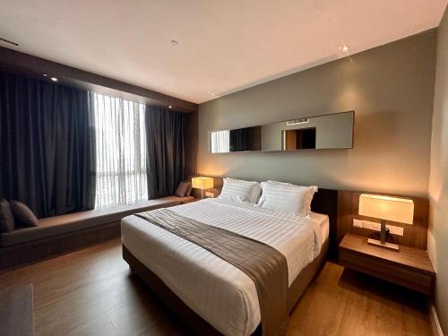 a hotel room with a large bed and a window at Swiss-Garden Hotel Melaka in Melaka