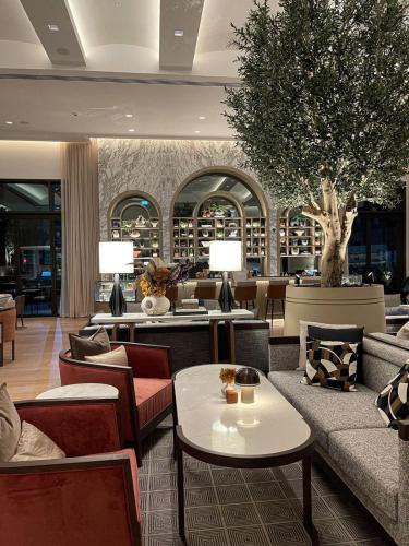 a lobby with couches and tables in a building at Palace Dubai Creek Harbour Residences Skyline Apartment in Dubai