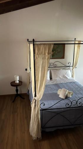 a bedroom with a bed with a canopy and a table at B&B Il Casale Del Ginepro in Migliano