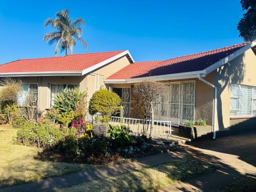 a house with a palm tree in the background at Horizon Bed and Breakfast in Roodepoort