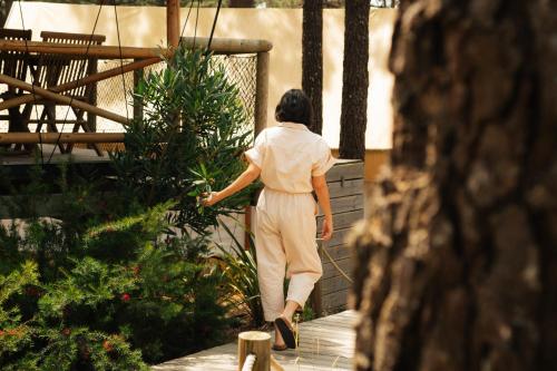 a woman walking down a walkway in a garden at Ohai Nazaré Outdoor Resort in Nazaré