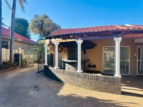 a house with a gate and a brick wall at Horizon Bed and Breakfast in Roodepoort