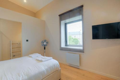 une chambre avec un lit et une télévision à écran plat dans l'établissement Superbe appartement rénové et lumineux, Salvagny, à La Tour-de-Salvagny