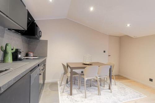 une cuisine avec une table et des chaises dans une cuisine dans l'établissement Superbe appartement rénové et lumineux, Salvagny, à La Tour-de-Salvagny