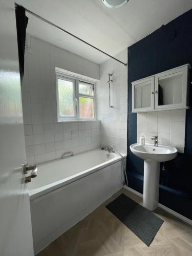 a bathroom with a white tub and a sink at House se3 8rp in London