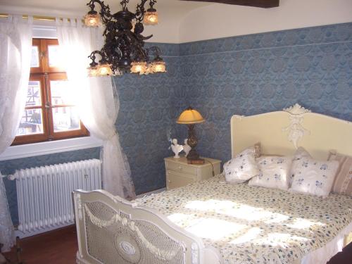 a bedroom with a white bed with blue walls at Roter Löwe in Heiligkreuzsteinach