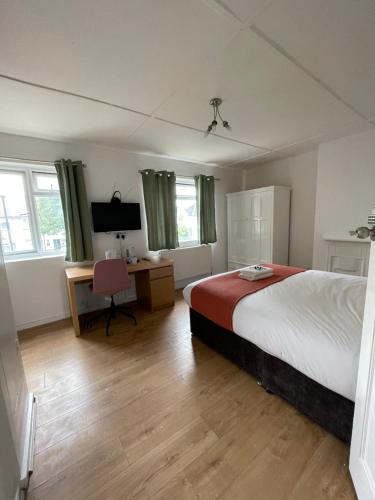 a bedroom with a bed and a desk with a chair at House se3 8rp in London