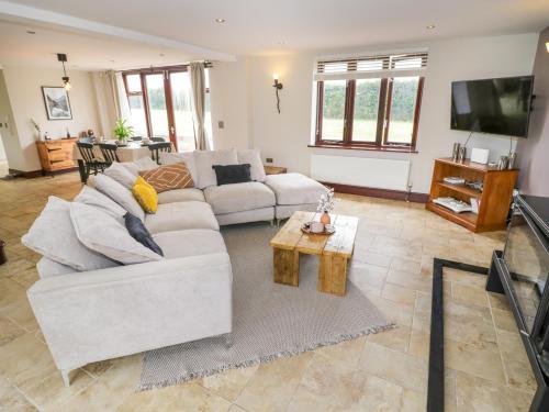 a living room with a couch and a table at Little Acre in Evesham