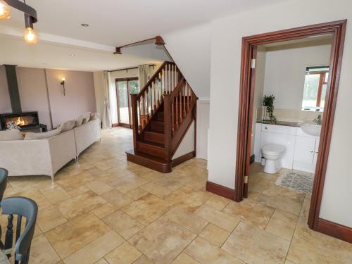a living room with a staircase and a couch at Little Acre in Evesham