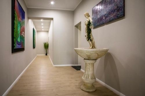 a hallway with a statue of a woman on a pedestal in a art gallery at HANNIBAL - Design Apartment Lavendel 4, VW Nähe, Parkplatz, Küche, HighSpeed-WLAN, Fitness, Solarium in Wolfsburg