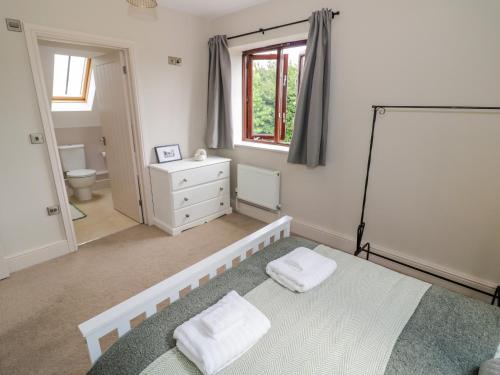 a bedroom with a bed with two towels on it at Little Acre in Evesham