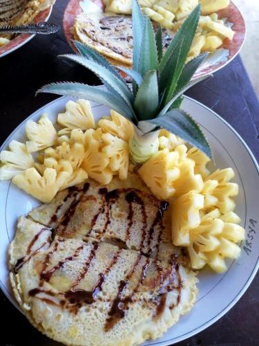 a plate of food with meat and pasta on a table at Padi Bungalow in Tetebatu