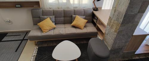 a couch with two pillows on it in a room at Студио Нико - Царево in Tsarevo