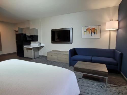 a hotel room with a bed and a couch and a tv at Holiday Inn Express San Diego South - Chula Vista by IHG in Chula Vista