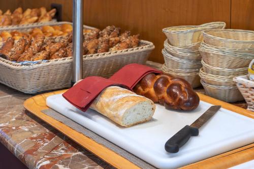 a table with bread and pastries on a cutting board at Hotel Delfino Lugano in Lugano