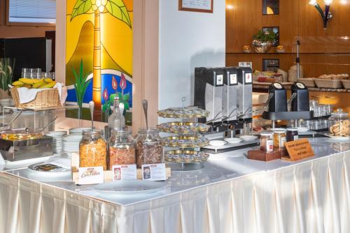 a buffet line with various food items on a table at Hotel Delfino Lugano in Lugano