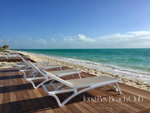 a row of lounge chairs on the beach at Long Bay Beach Club in Long Bay Hills