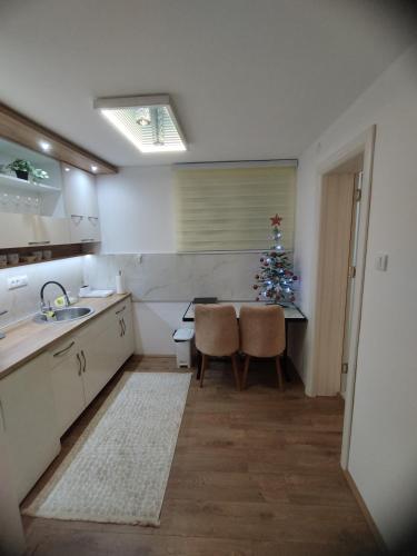 a kitchen with a christmas tree and a table and chairs at Sweet Dreams in Gornji Milanovac