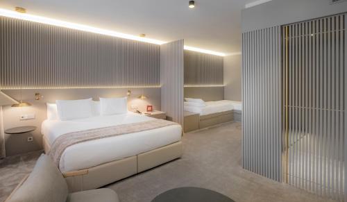 a bedroom with a large white bed and a bathroom at Carlemany Girona in Girona
