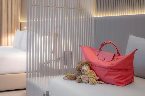 a stuffed teddy bear sitting next to a red purse at Carlemany Girona in Girona