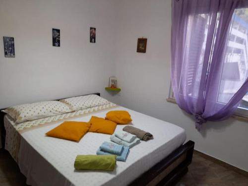 a bed with towels on it in a room with a window at Il Faro in Scalea