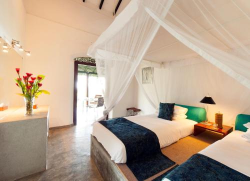 a bedroom with two beds and a window at Apa Villa Thalpe in Unawatuna