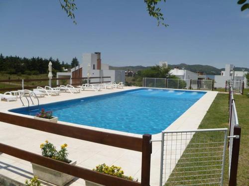 una grande piscina con sedie bianche intorno di Cerro Molinos a Potrero de Garay