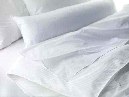 a white comforter laying on top of a bed at Sheraton Rockville Hotel in Rockville