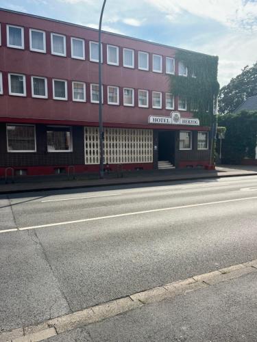 a red building on the side of a street at Hotel Herzog in Hamm