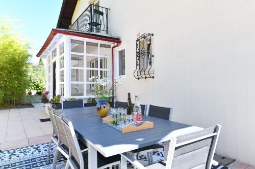 une table et des chaises bleues sur une terrasse dans l'établissement Gîte les Rosiers du Blosen, à Thann