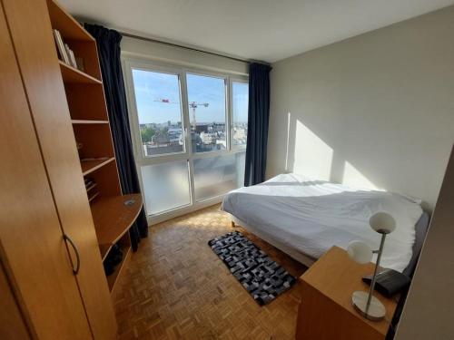 une chambre avec un lit et une grande fenêtre dans l'établissement FLAT with TOUR EIFFEL view and Montmartre, à Paris