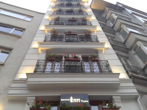 a tall building with balconies and plants on it at Rooms Inn Taxim in Istanbul