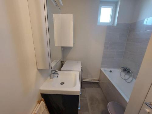 une salle de bain avec un lavabo, un miroir et une baignoire dans l'établissement FLAT with TOUR EIFFEL view and Montmartre, à Paris