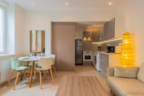 une cuisine et un salon avec une table et des chaises dans l'établissement Appartement une chambre, proche métro, à Lille