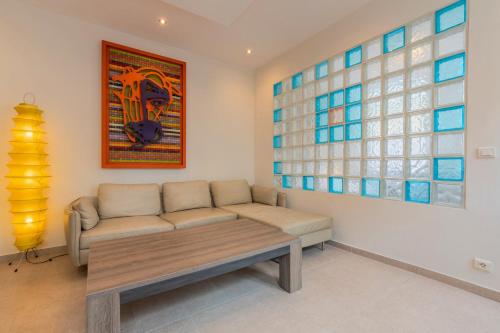 - un salon avec un canapé et un tableau dans l'établissement Appartement une chambre, proche métro, à Lille