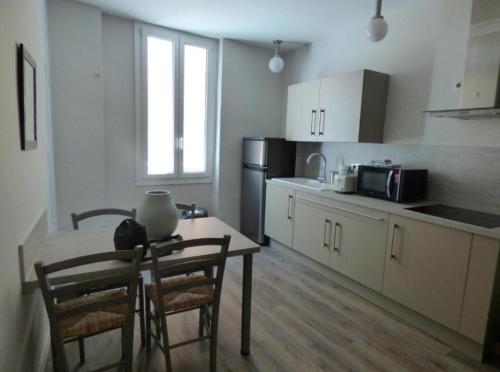 a kitchen with a table and chairs and a refrigerator at MISTRAL Gagnant in Cassis