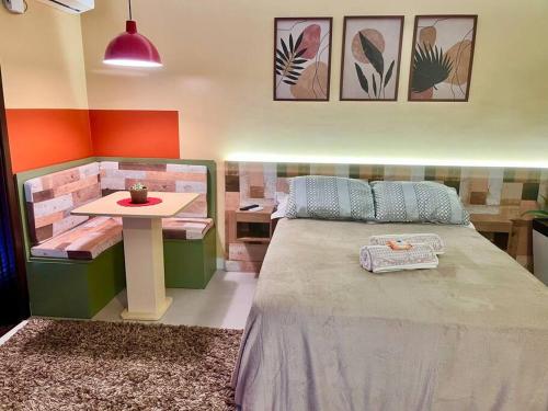 a bedroom with a large bed and a table at Studio Completo Super Aconchegante in Santa Cruz do Sul