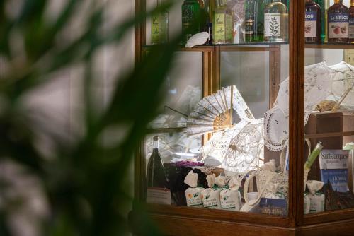 a glass case with an umbrella and bottles of wine at The Originals City, Hôtel Bristol, Le Puy-en-Velay in Le Puy en Velay