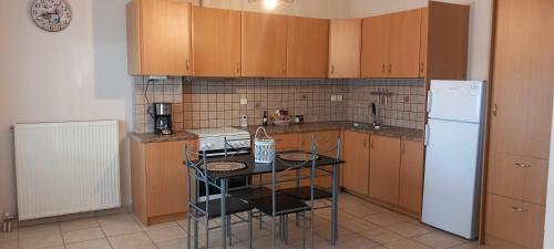 a kitchen with a table and a white refrigerator at La casa bella di Chalkida in Chalkida